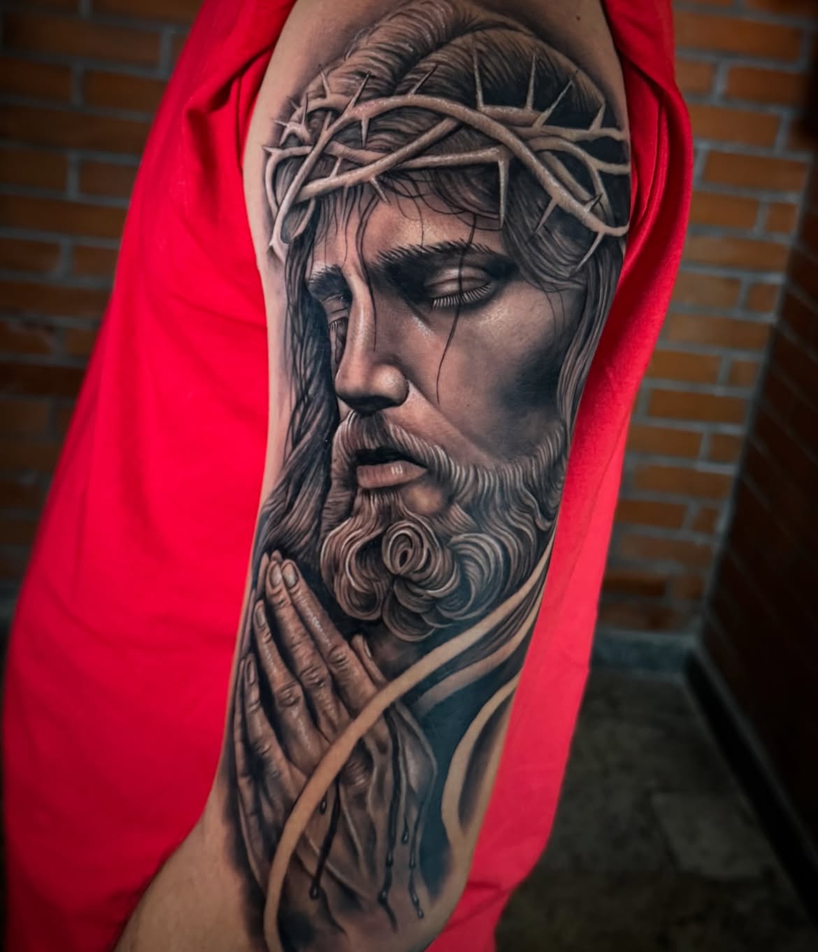 Tatuagem realista de Jesus com coroa de espinhos no braço — Tainan Santos