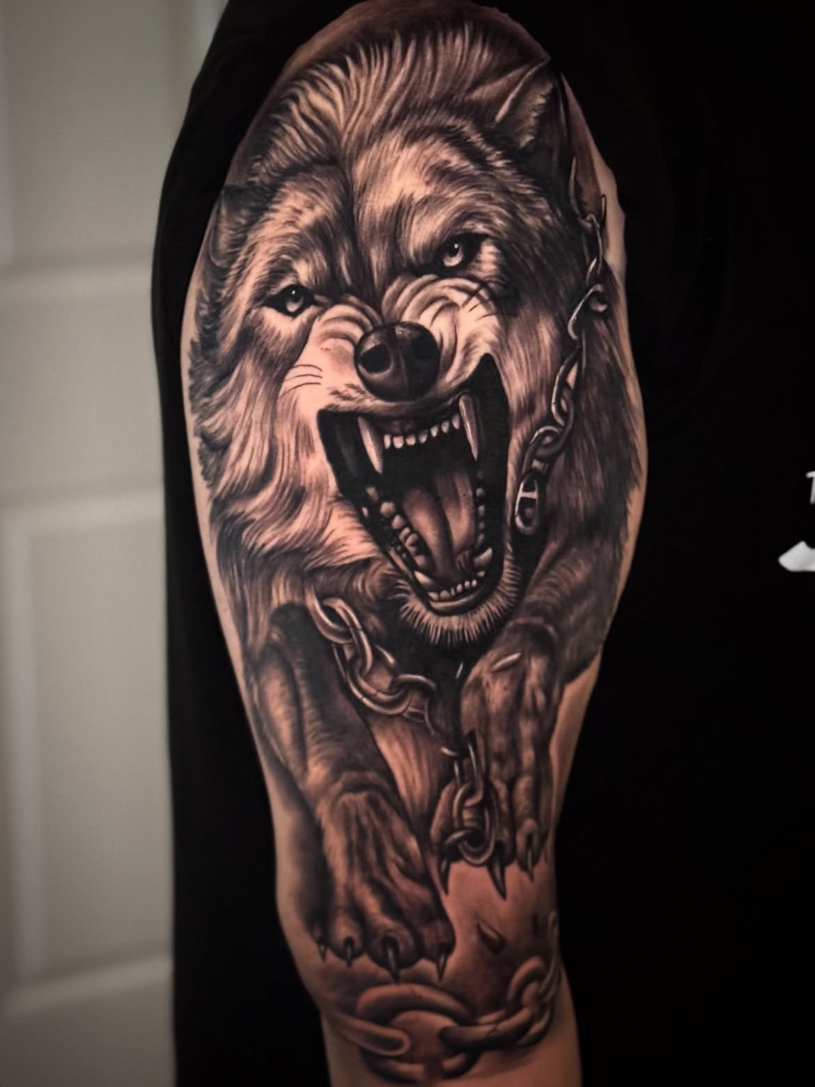 Tatuagem realista de lobo com correntes no braço — Tainan Santos