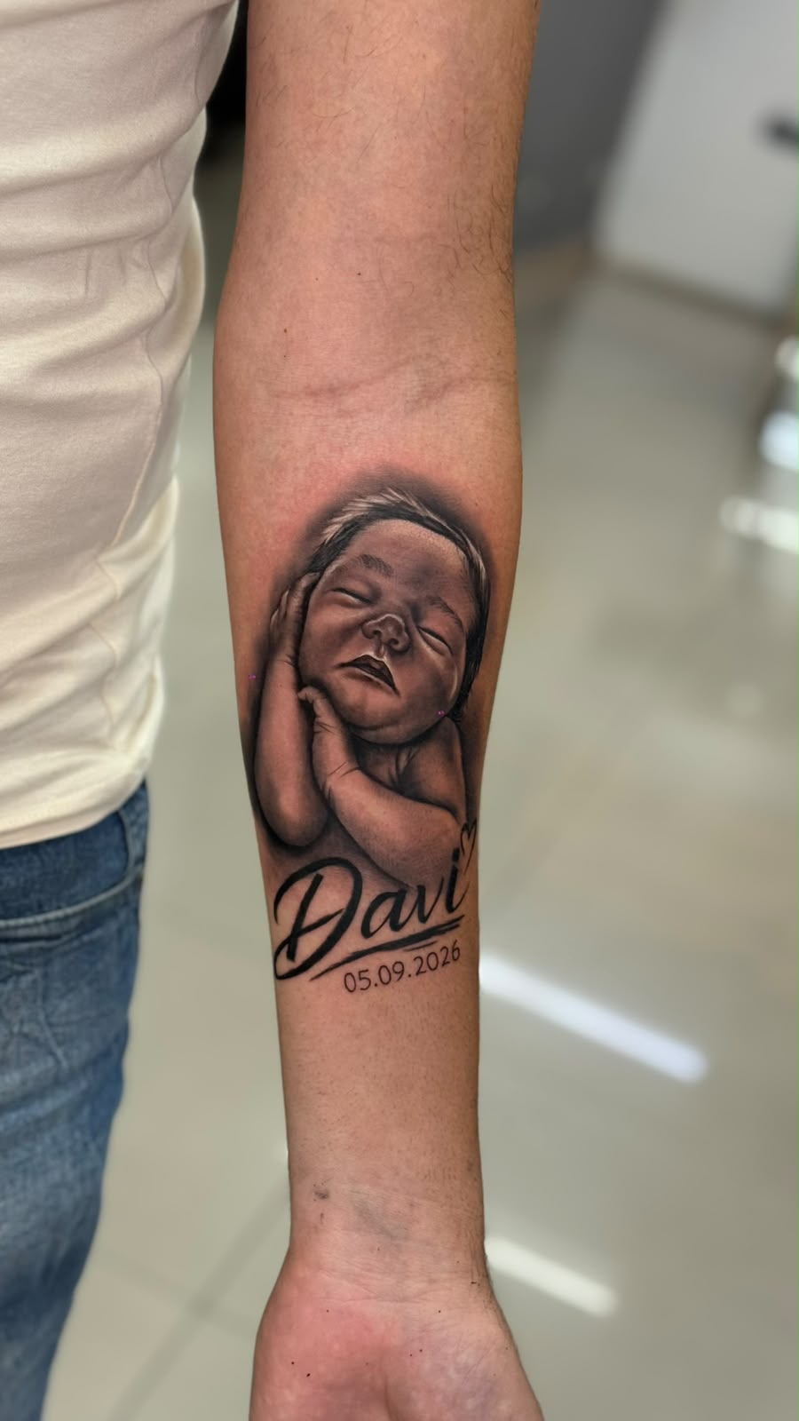 Retrato de bebê com nome Davi no antebraço — Tainan Santos